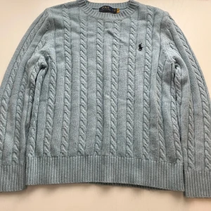 Ljusblå kabelstickad tröja Polo Ralph Lauren - Kabelstickad ljusblå tröja från Polo Ralph Lauren i storlek XL. OBS den sitter som L