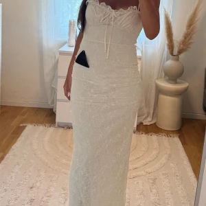 Vit långklänning med spets och snörning - Gina tricot klänning storlek 38. Helt nytt skick med prislapp på. 