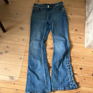 Ett par blå bootcut jeans med, detaljer på sidorna  - Jätte fina jeans från hm med fina detaljer på sidan i bra skick!