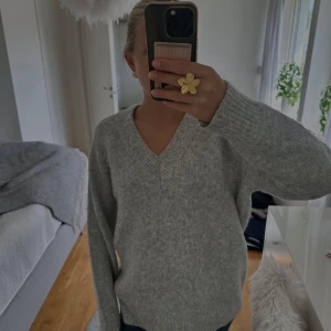 Grå stickad v-ringad tröja - Mysig grå stickad tröja från New Yorker med v-ringning och långa ärmar. Tröjan har en avslappnad passform och ribbade muddar vid hals, ärmslut och nederkant. Perfekt inför vintern❄️