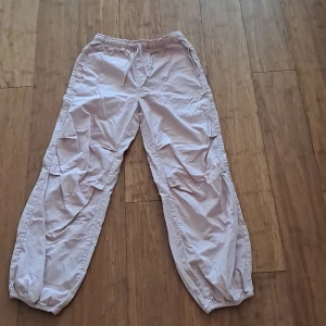 Ljusrosa cargopants från H&M - Säljer ett par ljusrosa cargopants från H&M med resår i midjan och benslut. Byxorna har flera fickor på sidorna och baktill, samt en loose passform. Perfekta för en chill och avslappnad stil. Dom ör i storlek 140.                                               Skriv så fort du har funderingar mvh stina.