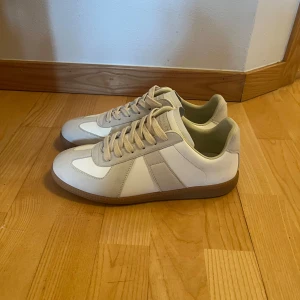 Maison Margiela gats - ❗️Pris går att diskutera, kontakta mig för byte❗️Maison Margiela gats i beige och vitt med klassisk en klassisk design. Perfekt för sensommaren. Skorna är i nästintill perfekt skick med undantag av två fläckar som ganska enkelt borde försvinna. Storlek 42
