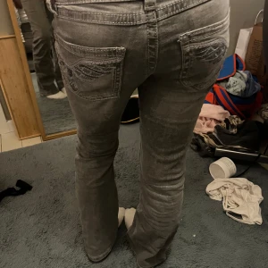 Grå bootcut jeans från Gina Tricot - Snygga grå jeans från Gina Tricot i storlek 152. Modellen har bootcut-ben och coola broderade detaljer på bakfickorna. Jeansen har klassisk femficksdesign och är tillverkade i ett mjukt jeansmaterial med lite stretch för skön passform. Det finns en liten fläck på höger knä men det syns knappt. Det finns en bild på fläcken☺️