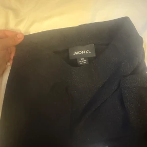 Svarta vida byxor från Monki XS - Säljer ett par svarta byxor från Monki i storlek XS. De har en hög midja och vida ben för en chill och trendig look. Perfekta att styla med crop top eller oversized hoodie. Materialet känns mjukt och bekvämt mot huden. och de är även glittriga lite