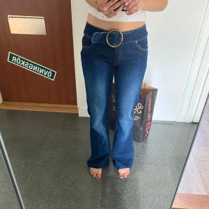 Lågmidjade utsvängda jeans - Coola lågidjade jeans med stort bälte och som är utsvängda. 