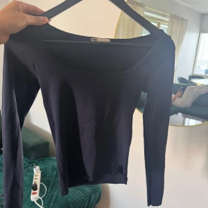 Svart långärmad topp med rund hals - En stilren svart långärmad topp från Gina Tricot med rundad halsringning. Perfekt att matcha med jeans eller kjol för en clean look. Mjuk och stretchig bomullskvalitet som sitter skönt på kroppen.