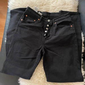 Snygg  tidlös Levi’s 501 bootcut! -  Klassiska Levi’s 501 i svart, straight fit med hög midja. Fem fickor, silverknappar, koppardetaljer och ikonisk läderpatch bak. Tidlösa jeans som passar till allt!         W27 L30  