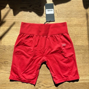Röda seamless shorts från ICANIWILL - Seamless shorts från ICANIWILL med bred ribbad hög midja och diskret ICW-logga på sidan. I storlek L, aldrig använda, orginalförpackning finns kvar. 