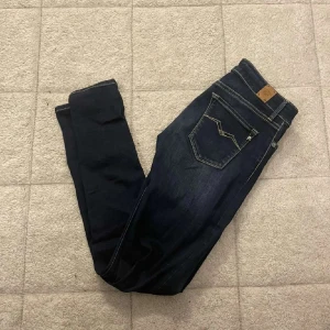 Mörkblå jeans med kontrastsömmar - Snygga mörkblå jeans med kontrastsömmar och klassisk femficksdesign. Jeansen har en smal passform och detaljerad bakficka med dekorativ söm. Perfekta till sneakers eller boots.