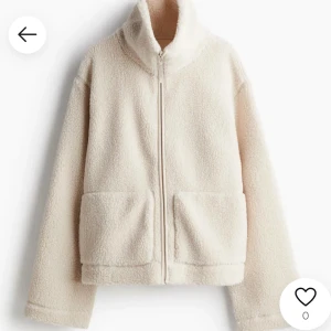Beige teddyjacka med dragkedja - Helt slutsåld mysig beige teddyjacka med dragkedja och hög krage. Jackan har långa ärmar och två stora fickor framtill. Perfekt för kyliga dagar när du vill hålla dig varm och bekväm.
