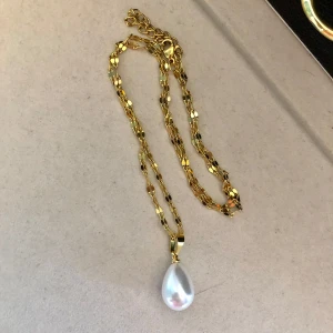 Guldhalsband med drop pärla  - Elegant och lyxigt halsband med ett vackert pärlhänge som är format som en droppe . Kedjan är gjord av stainless steel med 18 karat guld utanpå. Använt några gånger men stort sett nyskick. Lite större modell på hänget väldigt snygg till både vardag och fest 