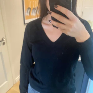 Svart tröja i 100% ull från Filippa K - Säljer en stilren svart tröja från Filippa K. Tröjan har en v-ringad design och är gjord i 100% ull. Använd endast fåtal gånger. 