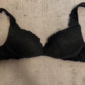 Svart spets-bh - Snygg svart bh med spetsdetaljer från Intimissimi i storlek 75b . Perfekt för att känna sig extra fin. Justerbara axelband för bästa passform. Endast använd 1 gång då den tyvärr är för liten, nypris 500 kr mitt pris 370 kr