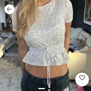 Vit prickig topp med volang - Söt vit blus med svarta prickar och korta ärmar🥰Säljer för att den inte kommer till användning🥰inte mina bilder