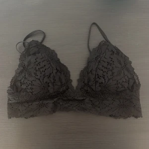Svart spets bralette från H&M - Snygg svart spets bralette från H&M med justerbara axelband och hakknäppning bak. Perfekt för en stilren och bekväm look. Spetsdetaljerna ger en elegant touch.
