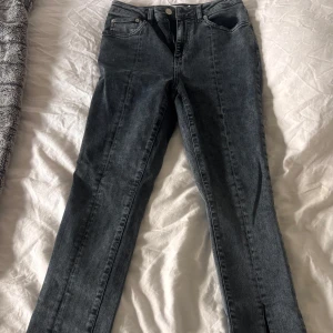 Gråa jeans med slits - Snygga gråa jeans med slits från NaKd. Jag har klippt till en bit på slitsen. De har aldrig använts då de är för långa för mig. Dom sitter dock väldigt skönt och fint. 