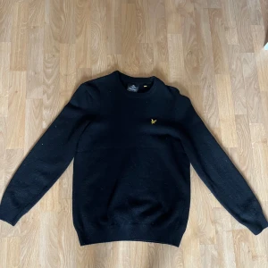 Svart tröja från Lyle & Scott - Säljer en stilren svart tröja från Lyle & Scott med deras ikoniska logga på bröstet. Tröjan har en klassisk design med rund hals och långa ärmar. Perfekt för en avslappnad men snygg look. Kan gå ner i pris vid snabb affär.