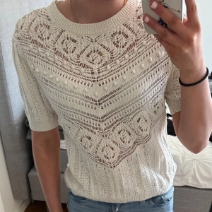 Vit stickad topp från Zara - Säljer en vit stickad topp från Zara med ett vackert spetsmönster. Toppen har korta ärmar och en rund halsringning. Storlek m men passar s