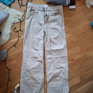 Beige byxor från ONLY - Säljer ett par snygga beige byxor från ONLY. De har en dragkedja och knapp framtill samt praktiska fickor. Perfekta för en avslappnad stil.