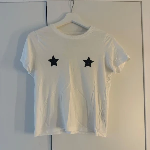 Vit t-shirt med stjärnor - Säljer en vit t-shirt med två svarta stjärnor. Storlek: Xs🩷🫶🏼