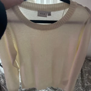 stickad tröja  - Säljer en stilren vit stickad tröja från VILA. Tröjan har en klassisk rund halsringning och långa ärmar. Perfekt för en mysig och avslappnad look. Passar bra till både jeans och kjol. oanvänd
