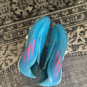 Blå fotbollsskor från Adidas - Säljer ett par blå fotbollsskor från Adidas det är elites. Skorna har en strömlinjeformad design och är perfekta för snabba rörelser på planen. De har en syntetisk ovandel och är designade för att ge bra grepp.  Har använt dem bara i 2 veckor men fick en knäskada och tyvärr kan jag inte spela mer fotboll :(