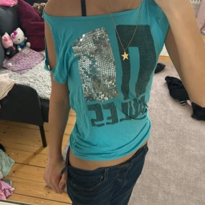 y2k stil turkos t-shirt med paljetter - Säljer en cool turkos t-shirt med texten 'NO RULES' i svart och en glittrig paljett-detalj. Perfekt om du går efter scene, mcbling eller 2000s tal stilen🩵💖Storlek 158-164. Går inte att köpa i butik längre !!🎀
