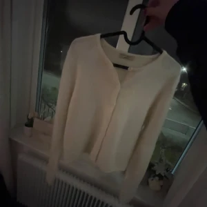 Vit kofta med knappar - Säljer en mysig vit kofta med knappar. Perfekt för kyliga dagar och enkel att matcha med olika outfits! Storlek: S🥰Säljer för väldigt bra pris!