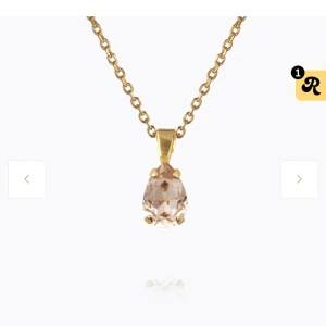 Guldhalsband med kristallhänge - Elegant guldhalsband med ett gnistrande kristallhänge. Kedjan är i en klassisk länkdesign och hänget har en vacker, facetterad kristall som fångar ljuset fint. Perfekt för att lägga till en touch av glamour till din look. Ny pris 695kr