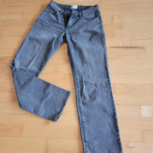 Grå A’99 low straight från Abrand - Snygga grå jeansbyxor med klassisk femficksdesign. De har en rak passform och är perfekta för en avslappnad stil. Byxorna har en knapp och dragkedja framtill samt hällor för bälte.