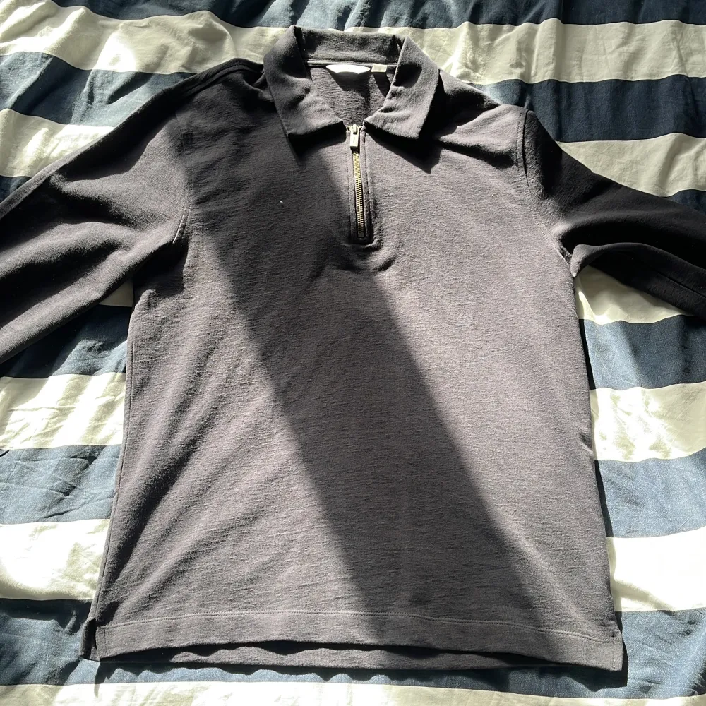 Snygg svart långärmad pikétröja från Dobber med dragkedja vid halsen. Perfekt för en stilren och avslappnad look. Tröjan har en klassisk krage och är tillverkad i ett bekvämt material.. Neuletakit & Villapaidat.