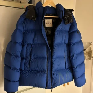 Monclear jacka  - Säljer nu min blåa dunjacka från Moncler. Jackan är i dun och är perfekt för vintern! Otroligt skön och varm. Nypris: 16.000kr. Har använts 1 vinter! Köptes från herr men jag är tjej och har haft den (lite oversized på mig som har S vanligtvis).  Den är i storlek S/M. Passar allt ifrån XS-M på tjejer och på killar S-M skulle jag säga.
