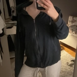 Mörkblå hoodie med dragkedja - Säljer en mörkblå hoodie med dragkedja och huva. Perfekt för en avslappnad stil. Den har långa ärmar och en bekväm passform.