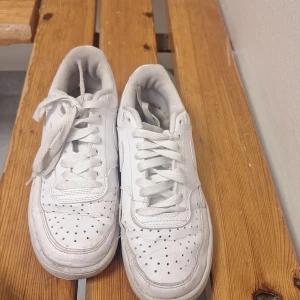 Vita sneakers med snörning - Säljer ett par klassiska vita sneakers med snörning. Skorna har en stilren design med perforerade detaljer på ovansidan för extra ventilation. Perfekta för en avslappnad stil.