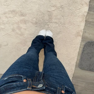 Mörkblå jeans med bootcut - Snygga mörkblå jeans med bootcut-stil. De har en klassisk femficksdesign och knappar i metall. Perfekta för en avslappnad look. Byxorna är knappt använda då de är för tajta på mig. Tveka inte att höra av dig vid frågor!💞