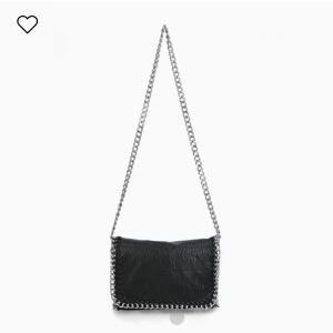 Svart axelväska med kedjedetaljer - Snygg svart axelväska i skinn med coola kedjedetaljer runt kanterna. Perfekt för att ge din outfit en edgy touch. Väskan har en lång kedjerem som gör den enkel att bära över axeln.