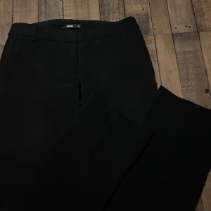 Svarta bootcut kostymbyxor från BikBok - Snygga svarta bootcut kostymbyxor från BikBok i storlek 38. Perfekta för en stilren look. Använda 5/6 gånger. 
