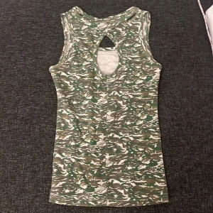Grön camo topp - Säljer en grön camo topp med ett coolt mönster på ryggen. Perfekt för en avslappnad stil. Det står att storleken är M men jag skulle säga XS💕