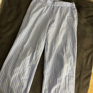 Randiga blå byxor från LMTD - Snygga blå byxor med vita ränder från LMTD. De är tillverkade i ett lätt och bekvämt material. Perfekt inför sommaren.