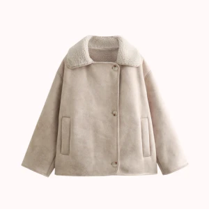 Beige teddyjacka med bred krage - Säljer en beige teddyjacka med bred, fluffig krage och raka ärmar. Jackan har en loose passform, knäppning med knappar framtill och två sidofickor. Materialet är mjukt och har en pälsliknande känsla, perfekt för kyliga dagar.