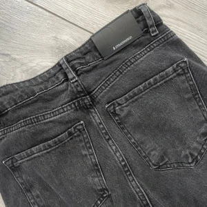 Jeans från Stradivarius - Säljer ett par svarta jeans från Stradivarius i storlek 34. Modellen har klassisk femficksdesign, raka ben och hög midja. Jeansen är tillverkade i denim med snygg tvättad look och har metallknapp och dragkedja framtill.