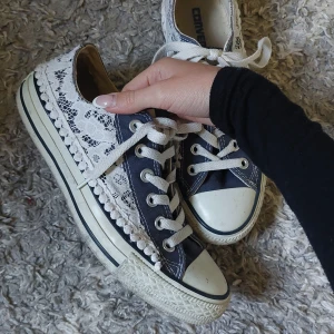 Converse sneakers i marinblått med spets - As snygga marinblåa sneakers från Converse med vit spetsdetalj på sidorna. Så fina men säljer då de är lite stora för mig. Köpte på plick och endast använda ett par gånger💕