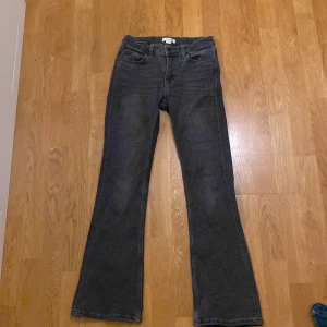 Svarta bootcut jeans - Säljer ett par svarta jeans med bootcut passform. De har klassisk femficksdesign, bälteshällor och dragkedja med knapp framtill. Jeansen är tillverkade i ett mjukt denimtyg som sitter skönt och har en snygg siluett med utsvängda ben.