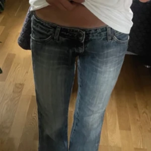 lågmidjade wrangler bootcut jeans - Säljer ett par blå jeans från wrangler med låg midja och bootcut passform. första bilder är lånade från förra ägaren, säljer vidare då de ej passade mig❤️midjemått: 37cm och innerbenslängd: 77cm!