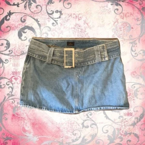 Jeanskjol med bälte från NLY Jeans - Snygg lågmidjad jeanskjol i storlek 42 från NLY Jeans. Dragkedja i sidan och tillhörande jeans bälte. Knappast andvänd säljer då den är för stor. Orginalpris 449kr. (Pris kan diskuteras)