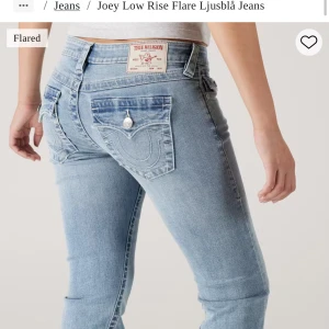 True Religion ljusblå bootcut jeans - Säljer ett par ljusblå jeans från True Religion med ikoniska broderade fickor och silverfärgade knappar bak. Modellen har låg midja och bootcut-ben som ger en snygg flare. Dom är i modellen joey. Dom är i stl 24 men dom sitter mer som en stl 25. Dom har gått sönder lite längst ner i sömmen men inget som påverkar byxorna eller nåt som syns. I övrigt inga defekter. Bara att höra av dig vid frågor!❤️