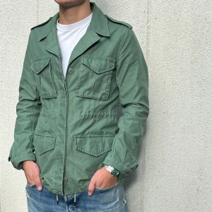 Grön fieldjacka med fickor - Snygg grön fieldjacka med fyra stora fickor framtill och klassisk krage. Jackan har knappar och snörning nedtill för extra stilpoäng. Perfekt för dig som gillar en chill och urban look. Hör av er vid frågor!👍