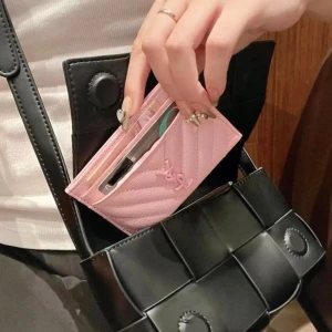Rosa YSL quiltad plånbok i skinn - Supersnygg rosa plånbok från YSL i quiltat skinn med klassisk logga framtill. Perfekt storlek för kort och cash, med flera fack och stilren design. Den ljusa rosa färgen och det lyxiga materialet gör den till ett måste i väskan.