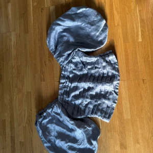 Silvrig blus med puffärmar från Kappahl - Säljer en silvrig blus från Kappahl i storlek S med stora puffärmar och glansigt tyg. Toppen har en croppad passform och snygga horisontella veck framtill som ger cool struktur. Perfekt för dig som gillar statement-plagg och vill sticka ut.