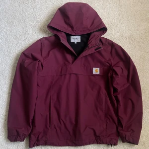 Vinröd Carhartt Anorak/Nimbus Pullover - Endast använd en gång så finns inga tecken på användning😊